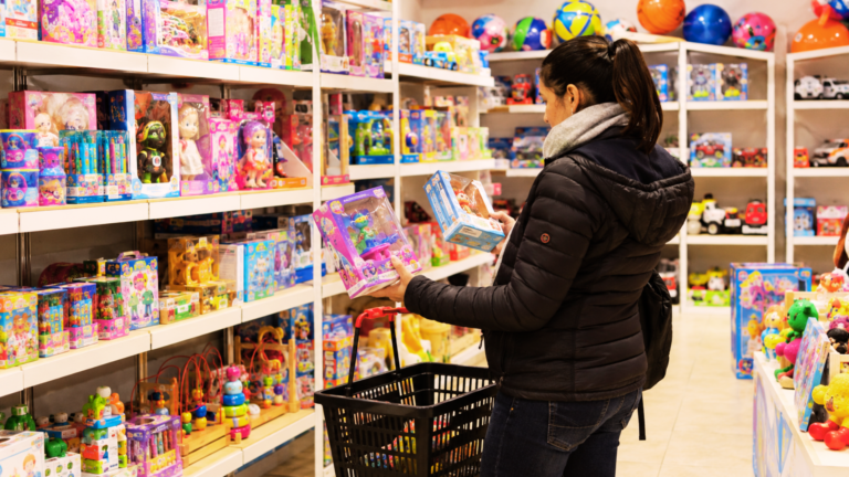 Mujer compara productos en una juguetería durante las compras por el Día del Niño.